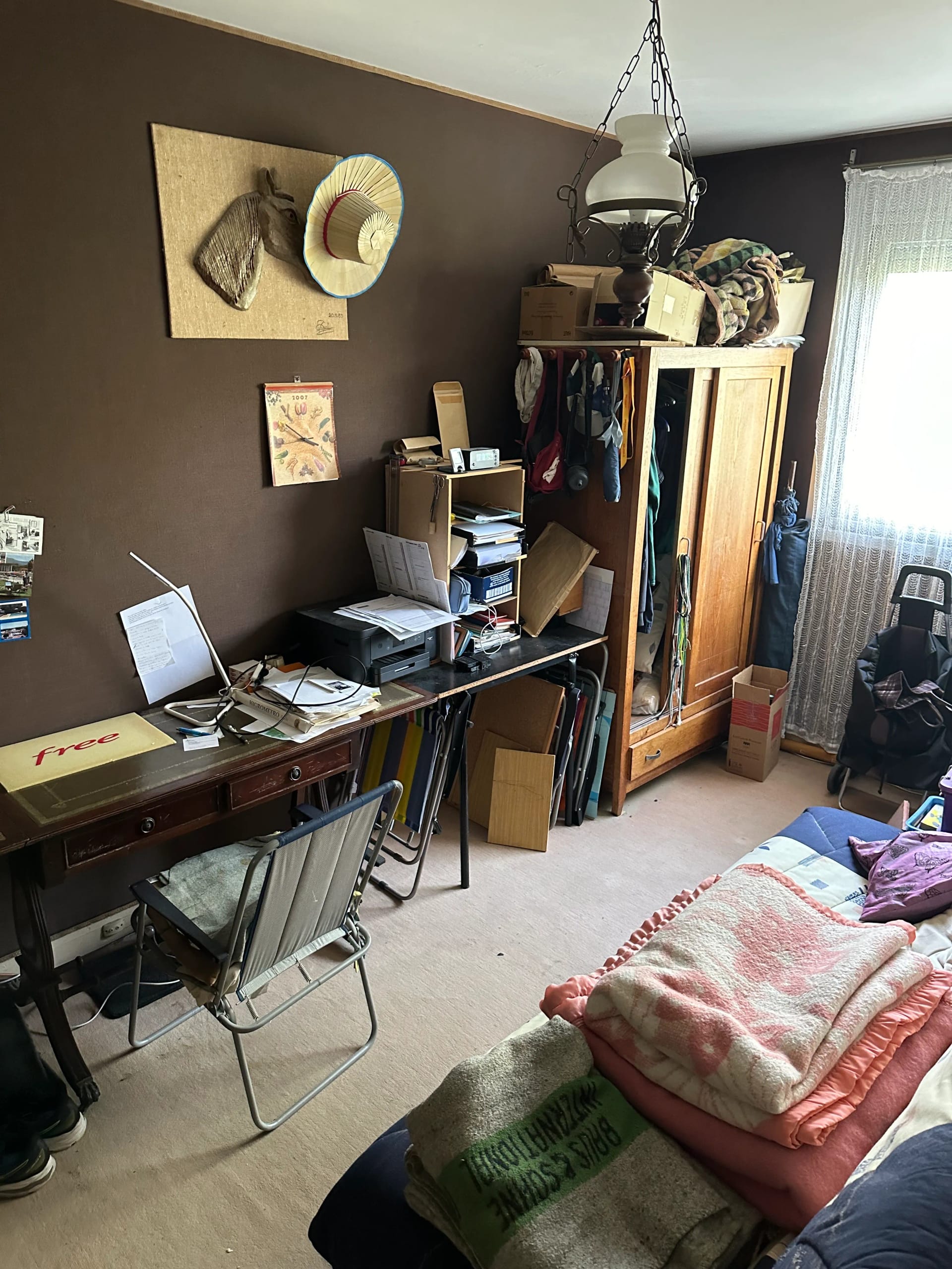 Débarras d'une chambre-bureau avec nombreux objets et meubles