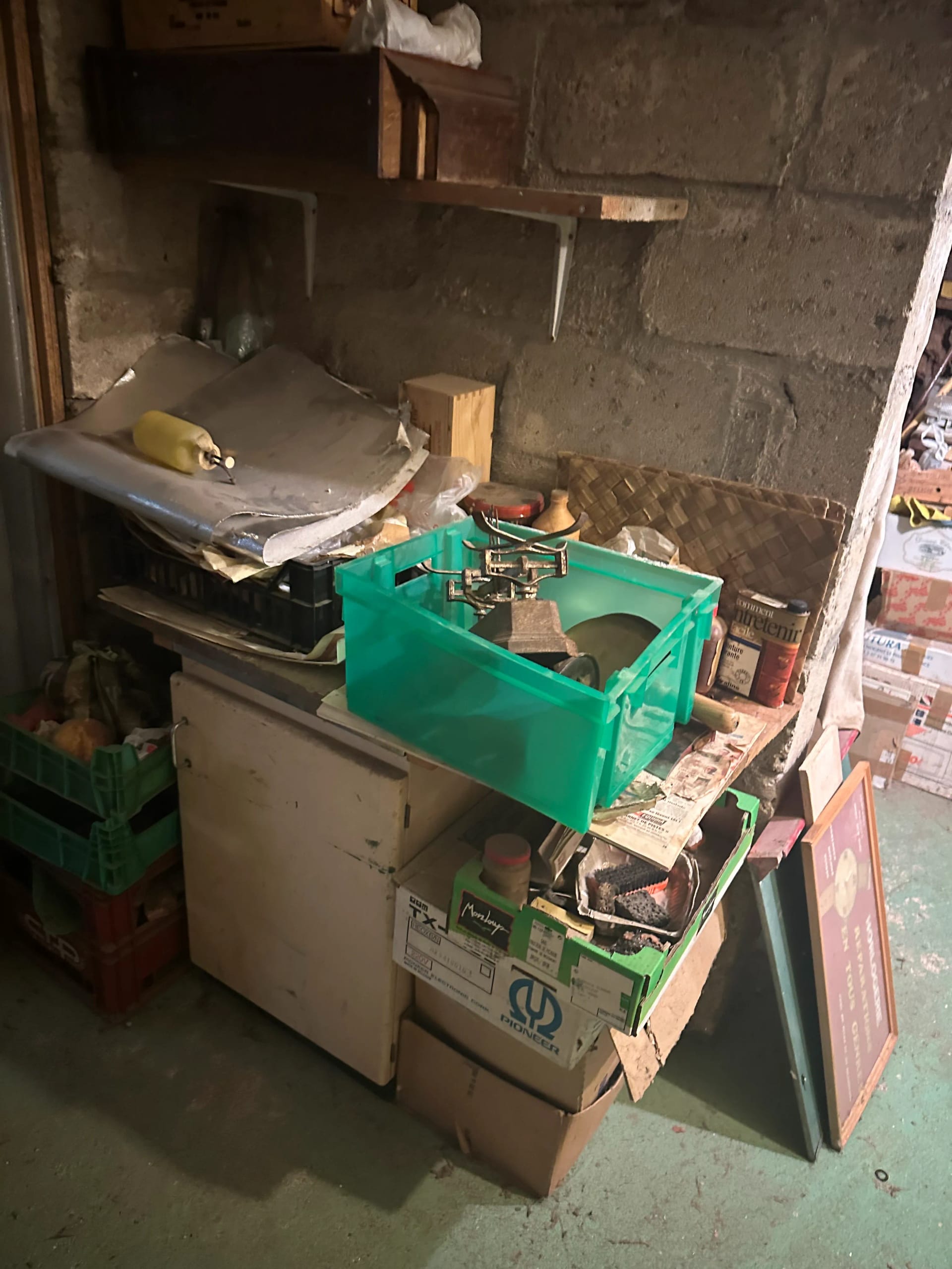 Débarras d'une cave avec réfrigérateur et caisses empilées à Paris