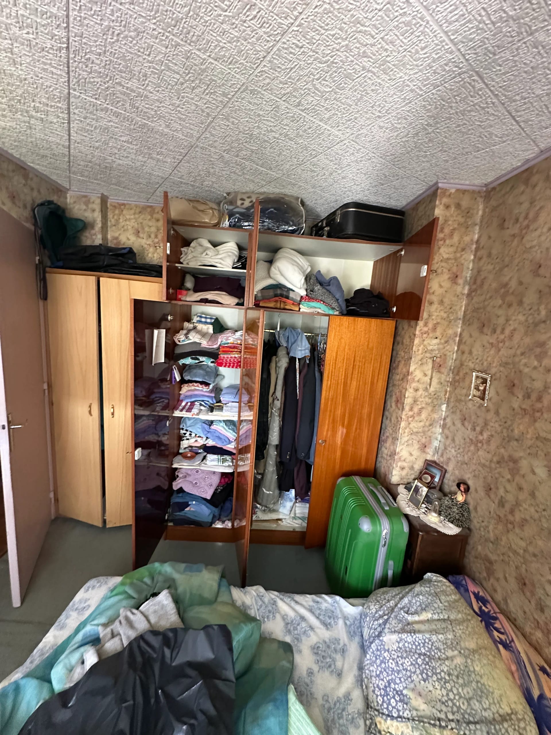 Débarras après décès - Vue d'ensemble d'une chambre avec armoires et effets personnels