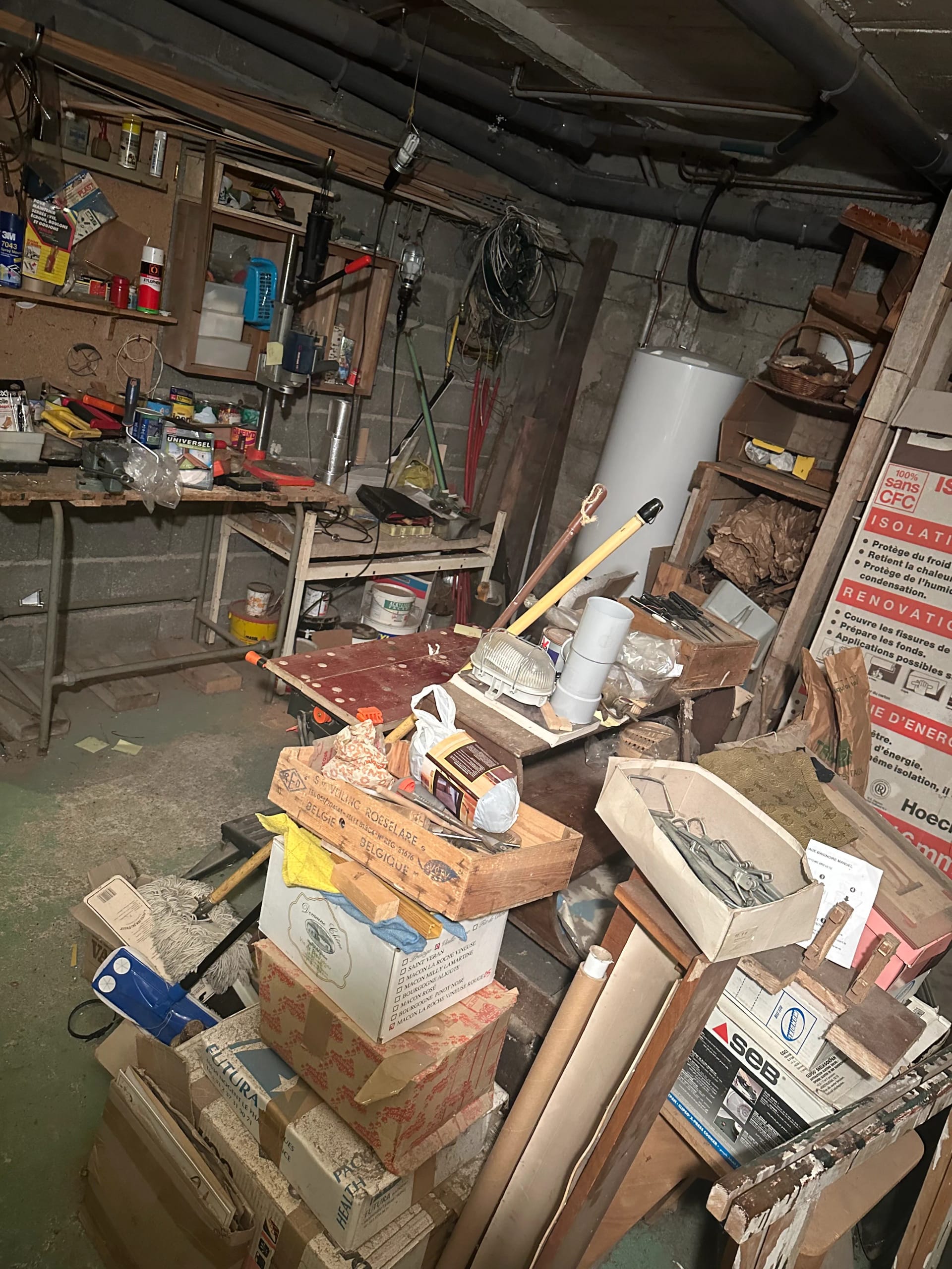 Cave-garage encombrée avec outils et matériaux de bricolage avant débarras