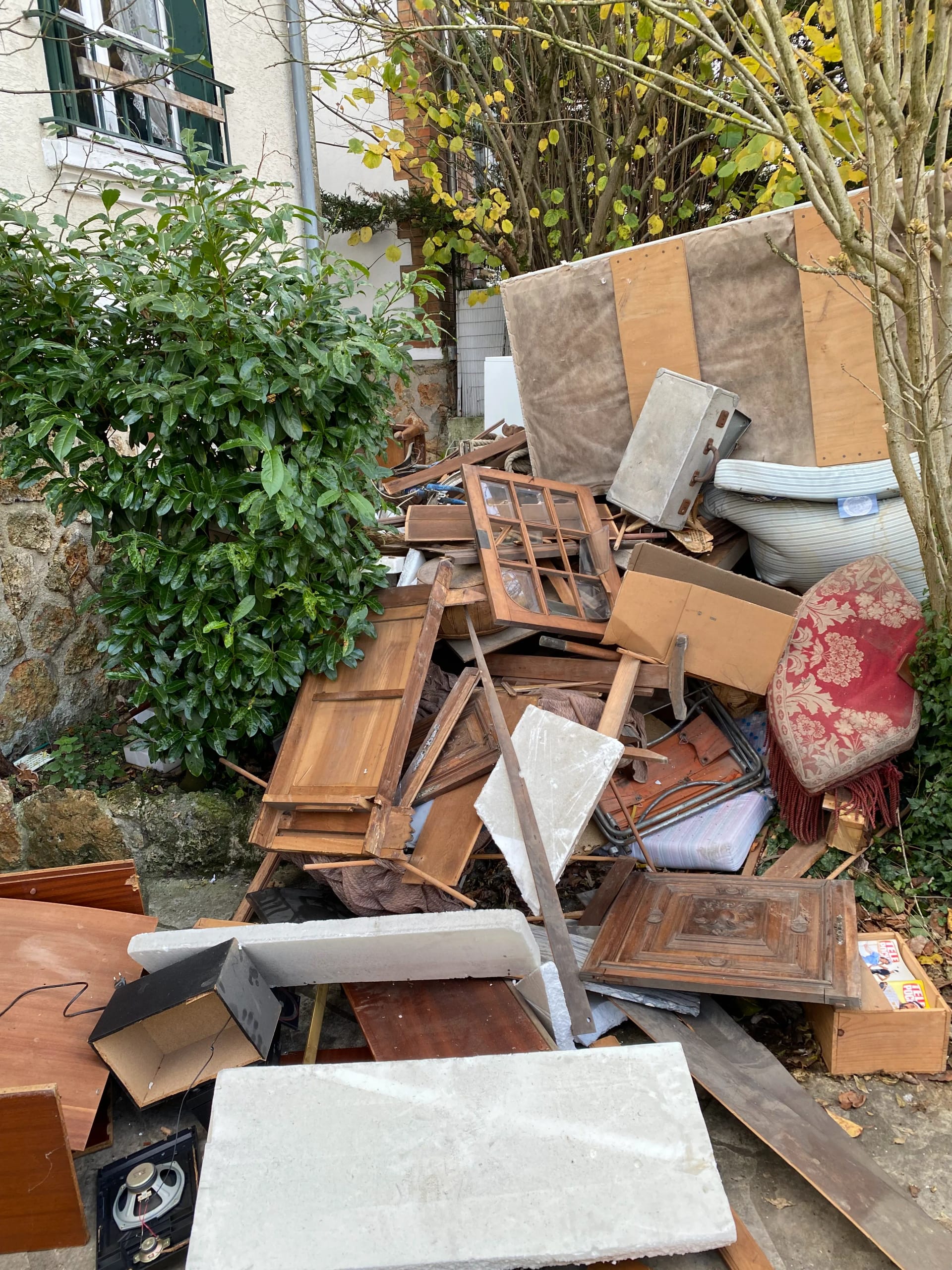 Débarras d'un jardin encombré de meubles cassés et divers objets