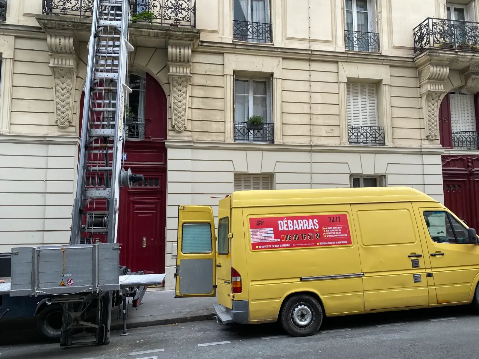 Camion jaune CAIA Débarras devant un immeuble parisien