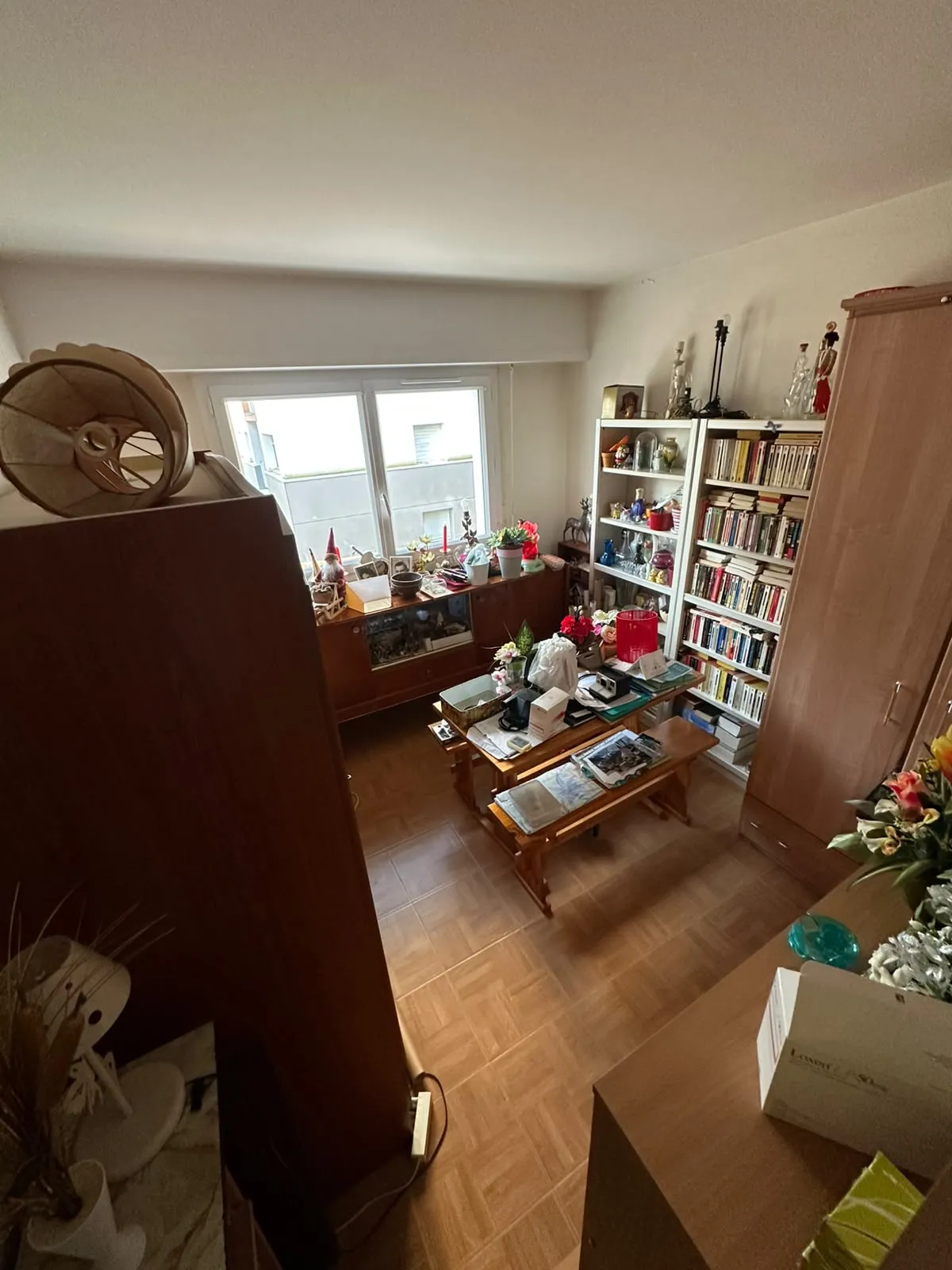 Chambre remplie de bibliothèques, d'une armoire et de tables basses chargées avant débarras