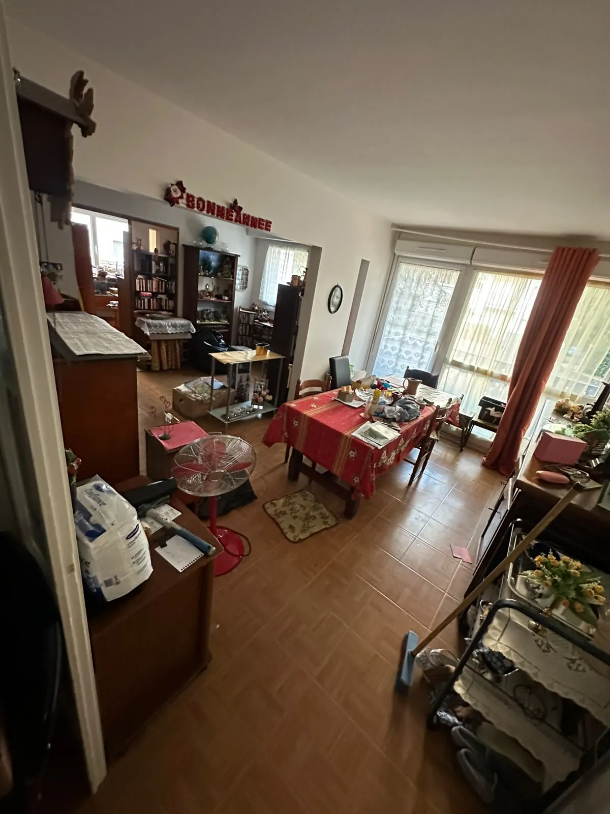 Salle à manger encombrée de meubles, cartons et objets divers avant l'intervention de CAIA Débarras
